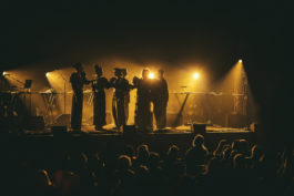 NYX choir live on stage, yellow lighting credit to Nathan Goldsworthy 